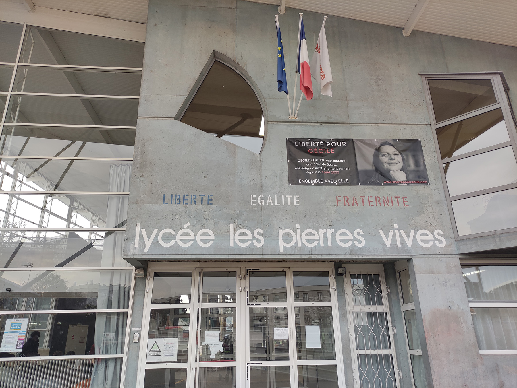 Façade du lycée Les Pierres Vives avec la banderole pour Cécile Kohler, otage d'État en Iran